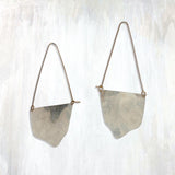 | fluid moon hoop | make a statement with the flowing, organic shape of the Fluid Moon Hoop earring; hand-cut and hammered sheet is suspended from long, triangular ear wires | available in bronze or sterling silver with 14K yellow gold-fill ear wires | #failjewelry